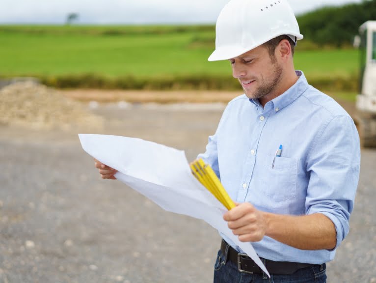 Someone in a hard hat checks regulations before using a shipping container