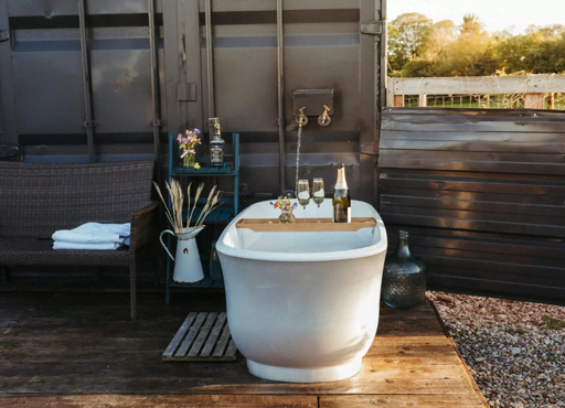 outside bathtub next to shipping container