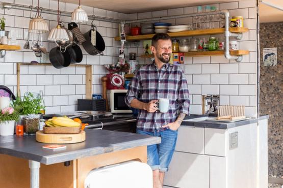 TV host Max McMurdo drinks a coffee in the kitchen of his shipping container home