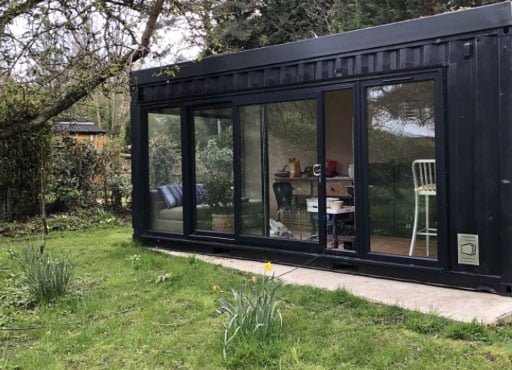 Dark shipping container office in garden