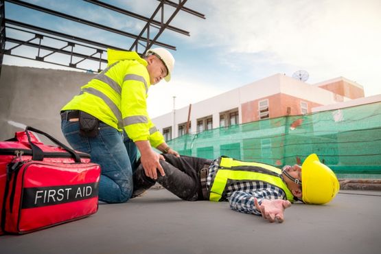 A first aider carries out first aid on a construction site