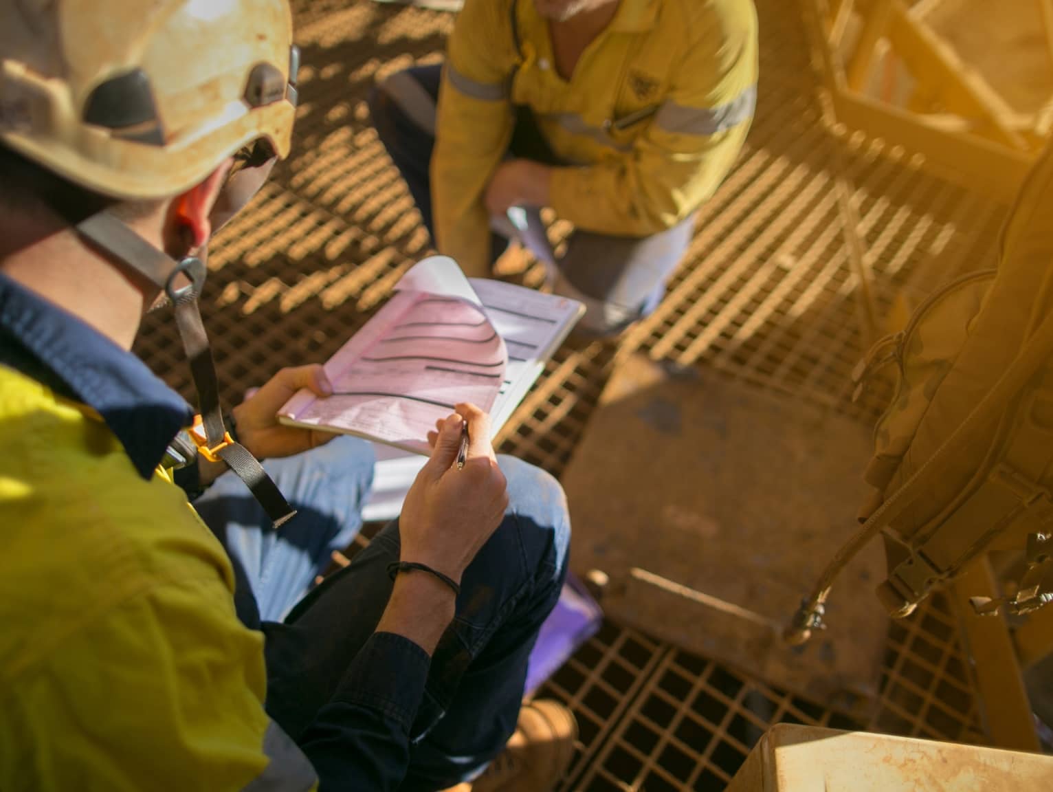 Construction workers reviewing plans on site in safety gear