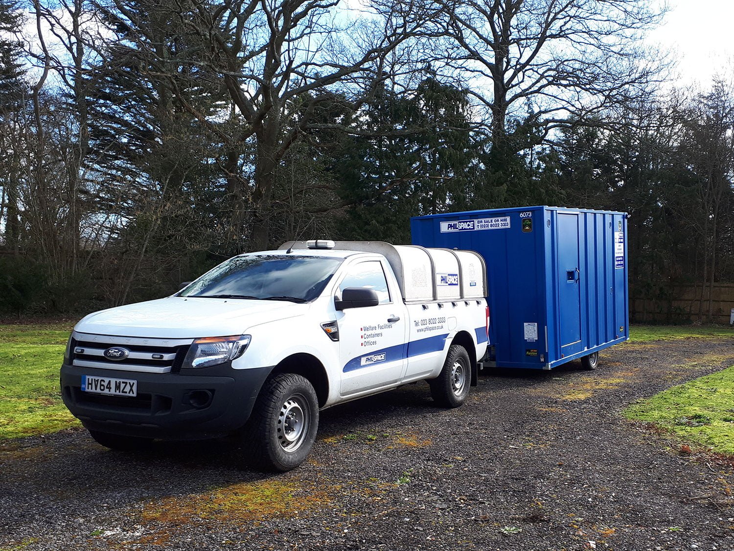 A branded white vehicle towing a branded Philspace welfare unit