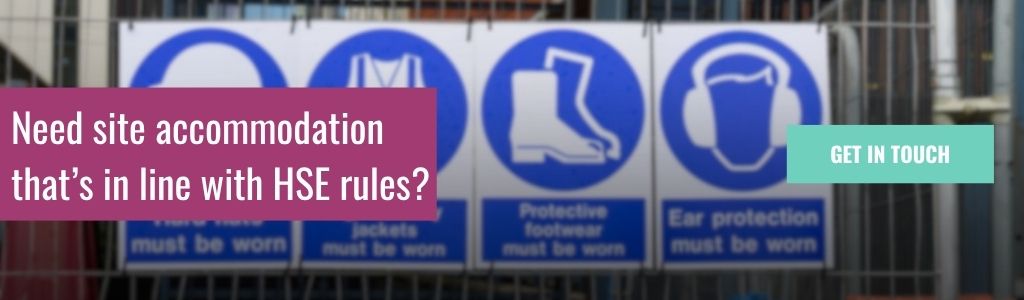 Need site accommodation that s in line with HSE rules: A banner reading "Need site accommodation that's in line with HSE rules?" over a blurred background of blue mandatory PPE signs on a construction site fence, with a teal "Get In Touch" button.