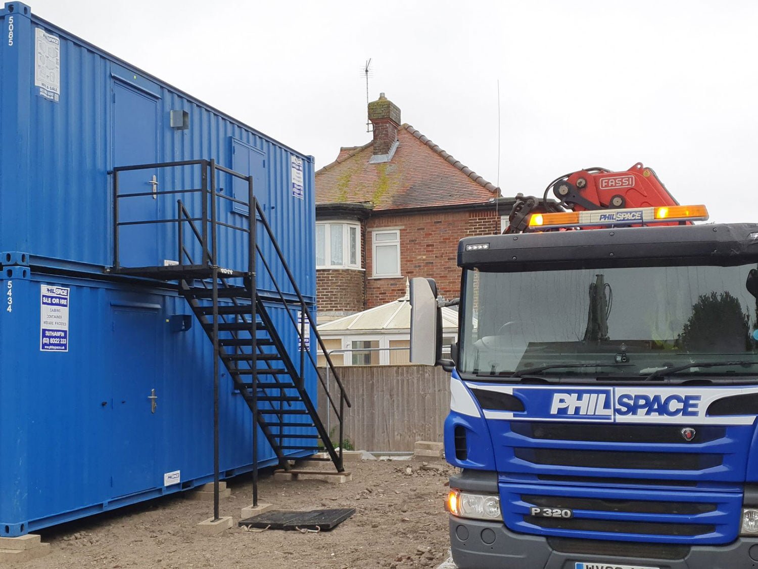 Two welfare units stacked on top of each other with a branded Philspace truck parked next to them