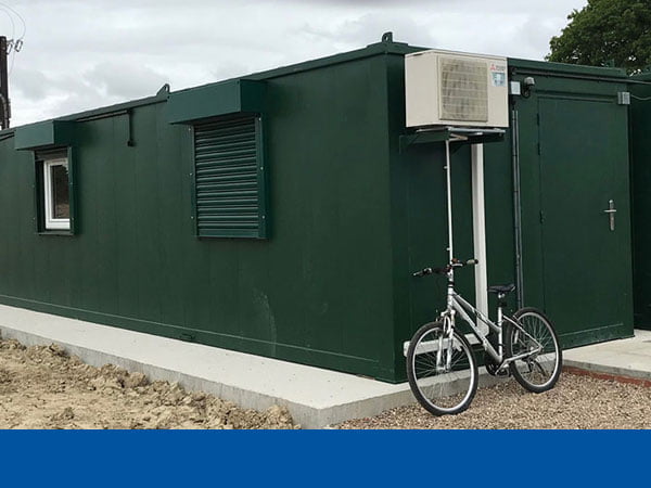 a green welfare unit with a bicycle leaning against it