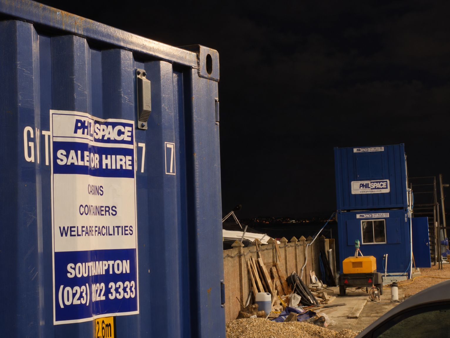 how-to-stop-tool-theft-on-construction-site: a blue philspace container on a southampton construction site at night in the uk
