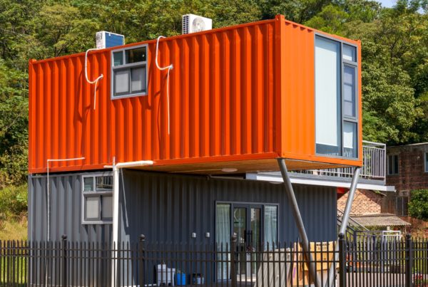 innovative uses for shipping containers: Converted shipping container building raised on supports, showing residential or commercial reuse of containers.