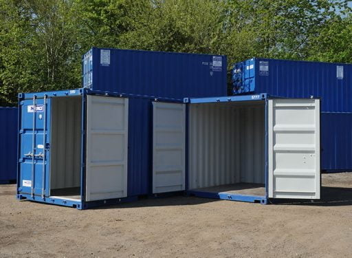 Several blue shipping containers in a yard